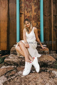 白裙少女倚古门石阶微笑