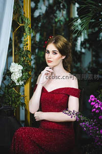 红裙佳人花园中，闪耀礼服与繁花相映成趣