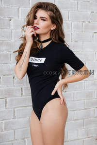 黑衣女子砖墙前摆姿