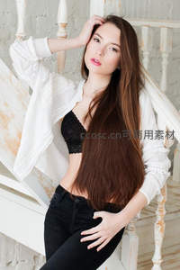 长发少女倚靠白色楼梯