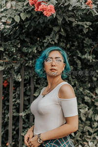 蓝发少女在绿植花墙前的时尚写真