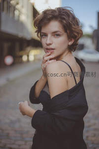 回眸一瞥的优雅瞬间，黑衣少女演绎街头浪漫风情