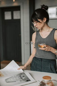 女子戴眼镜品茶阅读建筑画册