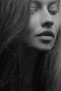 黑白柔光下闭目女子，长发飘逸显宁静