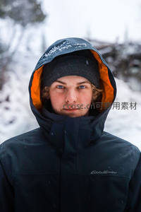 雪中少年黑衣橙帽目光坚定