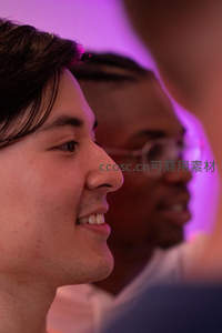 青年男子侧脸微笑沉浸紫色灯光中