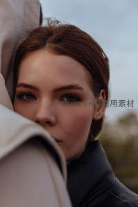 红发女子依偎在衣领旁凝视镜头