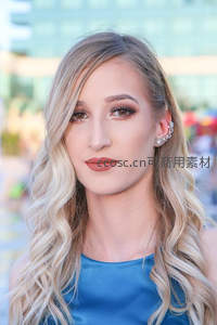 金发碧眼女子身着蓝色礼服微笑