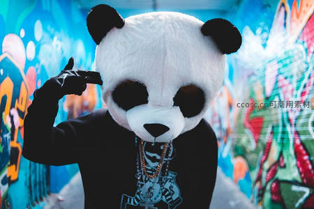 涂鸦墙前戴熊猫头套的潮人