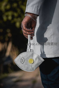 戴手套手持防护口罩的特写
