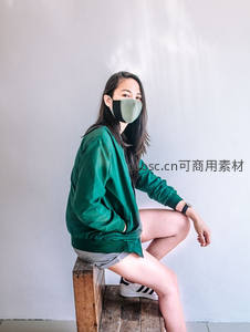 绿衣少女戴口罩坐木凳侧影