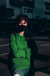 街头绿衣青年戴口罩凝视镜头