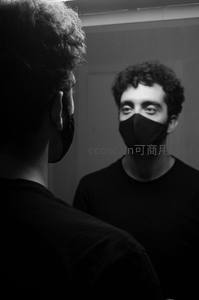 镜中男子戴口罩凝视自我