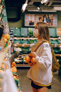 超市里戴口罩挑选橙子的女子