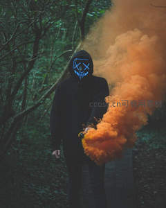 森林中持橙烟雾弹的发光面具人