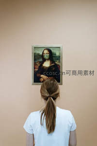 女子背影凝视戴口罩的蒙娜丽莎画像