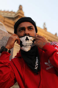 红衣男子调整骷髅面巾，古建前显潮流