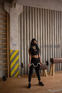 健身房内女子戴口罩举杠铃锻炼