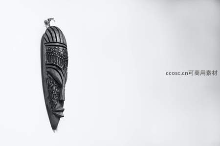 非洲风格木雕面具悬于纯白墙面