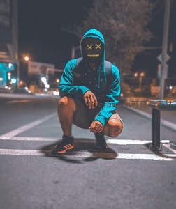 夜街蹲姿发光面具青年