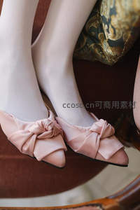粉色蝴蝶结平底鞋搭配丝袜的优雅特写