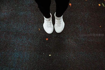 白色运动鞋踏在彩色橡胶地面上