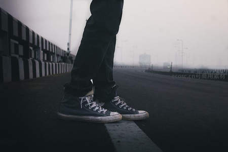 雾中街头，帆布鞋静立空旷公路的孤独剪影