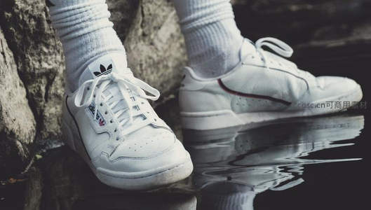 白色运动鞋映水边，简约时尚显活力