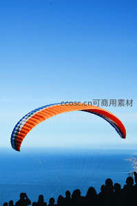彩色滑翔伞翱翔于蔚蓝海岸之上