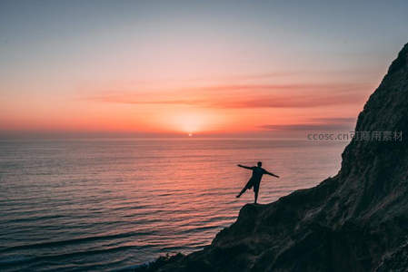 悬崖之上张开双臂迎日落
