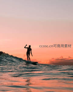 日落时分冲浪者高举手臂庆祝胜利瞬间