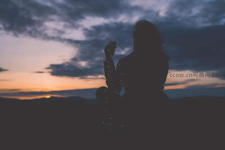 黄昏剪影女子手持烟花仰望天空