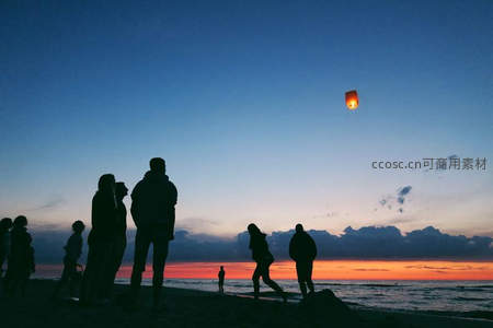 海滩夜空，孔明灯升向星河