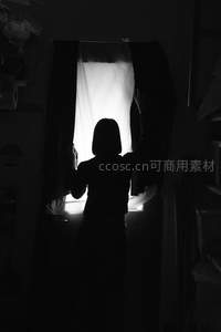 窗边拉开窗帘的剪影