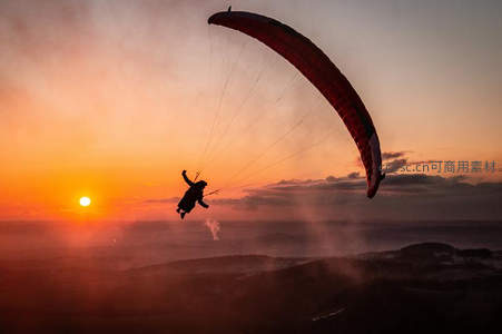 夕阳滑翔伞剪影，翱翔于云海之上