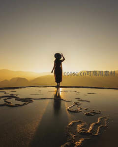 盐湖镜面，女子剪影映夕阳余晖