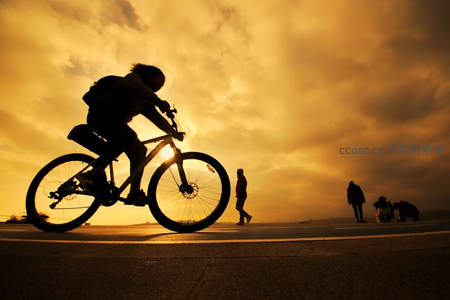 金色夕阳下的骑行者剪影