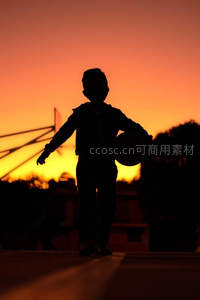 夕阳下持球奔跑的少年
