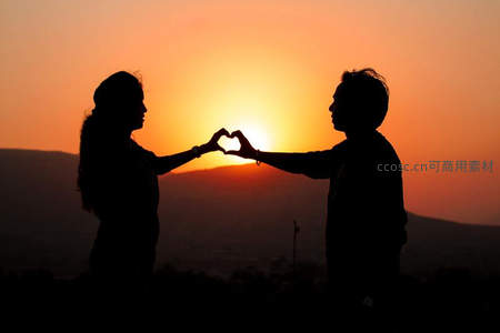 恋人双手比心定格夕阳美景