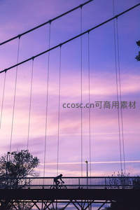 暮色悬桥单车掠影，粉紫天幕如梦似幻