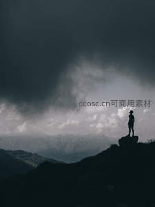 山巅孤影面对乌云密布的壮阔天际