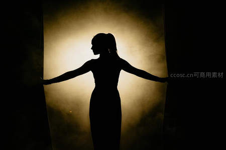 暖光烟幕中女子伸展双臂如翼