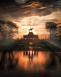 夕阳下骑马雕像的金色倒影