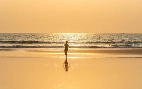 夕阳海滩孩童奔跑溅起水花倒影