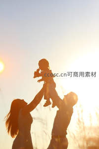 父母高举孩子迎向夕阳