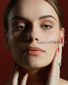 红甲女子优雅托腮凝视镜头