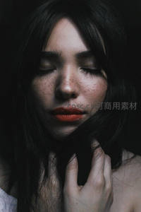 闭目沉思的黑发女子特写