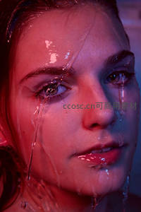 霓虹光影下水珠滑落脸庞