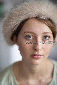 毛绒帽下蓝眸少女，纯净自然的温柔凝视