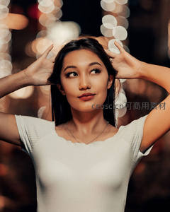 女子双手比角，背景光斑梦幻迷人